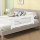 Foldable white bed rail guard for toddlers with soft padding, adjustable strap, and T-shaped legs for stability.