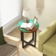 Round teak wood end table with epoxy resin top, featuring X-shaped legs, perfect for outdoor use on patios or balconies.