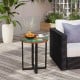 Round teak wood outdoor end table with epoxy resin top, featuring X-shaped legs, perfect for patio or balcony use.