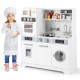 Wooden pretend play kitchen set in white with a child chef, complete with utensils for imaginative cooking and laundry.