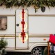 Three lighted Christmas wreaths with bows, featuring warm white LEDs, hung on a red ribbon for festive outdoor decor.