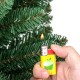 Hand holding a lighter igniting a branch of a Pencil Christmas Tree with warm LED lights and memory wire tips.