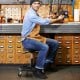 Pneumatic rolling mechanic stool with padded seat, adjustable height, and tool tray, ideal for workshop use.