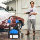 Electric pressure washer with wheels, 2300 PSI, 1.8 GPM, shown in use washing a car, featuring quick connect nozzles.