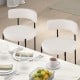 Set of two white boucle dining chairs with curved backrest and metal legs, perfect for dining or living room use.