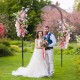 Outdoor metal garden arch trellis with floral decorations, perfect for weddings and climbing plants in a lush garden.