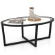 Oval glass coffee table showcasing a spacious surface for decor, featuring a black cross base and acacia wood legs.