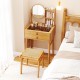 Small vanity desk set with mirror, bamboo material, two drawers, and glass tabletop for compact bedroom storage.