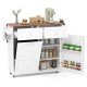 Rolling kitchen island in white with drop leaf top, storage drawers, and tilt-out trash cabinet on rubber wheels.