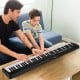 88-key foldable electric keyboard piano in black, featuring dual speakers, ideal for music practice and easy storage.
