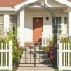 Garden arbor with gate featuring elegant flower decorations, black galvanized metal, and sturdy crossbars for stability.