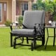 Patio glider rocking chair with gray thick cushion and curved armrests, perfect for outdoor relaxation.