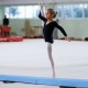 Child performing on a 7 FT folding balance beam with removable suede cover, ideal for home gymnastics training.