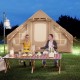 Inflatable camping tent for 4-6 people with mesh windows, set up outdoors for a cozy camping experience.