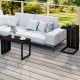 C-shaped black end table with adjustable foot pads, perfect for indoor or outdoor use, shown beside a sofa.