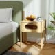 Bamboo nightstand with a decorated drawer, featuring a spacious tabletop and reeded glass, perfect for bedside storage.