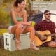 Portable tan cooler with integrated cup holders, supporting up to 220 lbs, ideal for camping and outdoor activities.