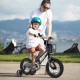 Child riding a 12-inch kids bike with basket and training wheels, featuring a sturdy metal frame and dual brake system.