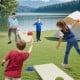 Solid wood cornhole board set with bean bags, perfect for outdoor games and easy transport with foldable legs.