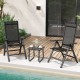 Two black outdoor dining chairs with padded seats and adjustable backrests, set on a wooden deck by the pool.