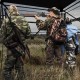 Hunting blind with camouflage pattern, 82" tall, accommodates 3-4 people, featuring one-way see-through panels for.