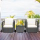 Two cushioned patio chairs and a glass-top table in a garden setting, perfect for outdoor relaxation.