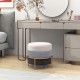 Round upholstered ottoman in gray with gold metal legs, perfect as a footrest or side table for versatile use.