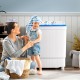 Portable washing machine with drain pump in a laundry setting, featuring dual tubs and a compact design for easy use.