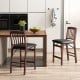 Set of 2 brown folding counter height chairs with padded seats, ideal for kitchen islands and space-saving storage.
