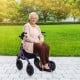 Height adjustable purple rollator walker with seat, featuring all-terrain wheels, in a park setting for seniors.