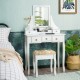 White makeup dressing vanity set with 5 drawers, padded stool, and rotating mirror for a stylish and functional setup.