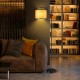 Standing floor lamp with adjustable head, matte black iron frame, and beige fabric shade for cozy living room lighting.