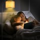 Standing floor lamp with adjustable head, matte black frame and beige fabric shade, perfect for cozy reading in bedroom.