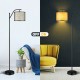 Standing floor lamp with adjustable head, matte black frame and beige fabric shade, perfect for living room or bedroom.