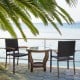 Set of 2 outdoor patio wicker dining chairs with curved acacia wood armrests, placed by the waterfront for relaxation.