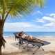 Folding retractable camping cot in blue with soft mattress, set up on the beach for outdoor relaxation.