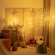 Pre-lit 4 ft white twig birch tree with 48 LED lights, creating a warm festive atmosphere for holiday indoor decoration.