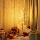 Bendable branches of the 4 ft pre-lit white twig birch tree with warm LED lights create a cozy holiday ambiance indoors.