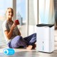 100-pint dehumidifier in white with smart app control, ideal for large rooms up to 5500 sq.ft, shown in a cozy setting.