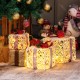 Set of 3 lighted Christmas gift boxes with red bows, featuring warm-white LED lights for festive outdoor decoration.