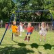 Kids enjoying the 440 Pounds Kids Swing Set with two swings and a glider in a backyard setting.