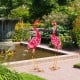 Two pink flamingo garden statues with U-shaped stakes, made of rustproof metal, perfect for backyard decoration.