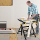 Folding work table with adjustable height and tiltable platform, featuring non-marring clamps for secure workpiece.