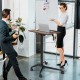 Pneumatic standing desk with adjustable height, anti-fall baffle, and cup holder, ideal for versatile workspace use.