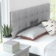 Gray linen upholstered headboard with button tufting, designed for full/queen beds, featuring solid rubber wood legs.