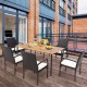 Patio dining set featuring four wicker armchairs with soft zippered cushions, ideal for outdoor dining on a balcony.