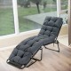 Thick gray outdoor lounge chaise cushion with string ties, made from waterproof polyester for garden or poolside use.