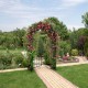 Garden arch arbor trellis with gate in black, adorned with vibrant flowers, enhancing garden appeal and creating an.