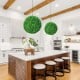 Two 19.5-inch faux boxwood topiary balls in a modern kitchen setting, adding vibrant greenery to the space.