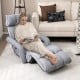 Adjustable gray floor chair with armrests and footrest, perfect for relaxation in living rooms or bedrooms.